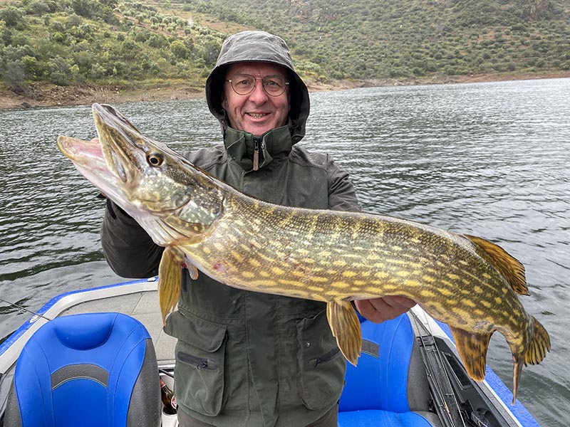Pecheur avec un brochet sur un lac portugais