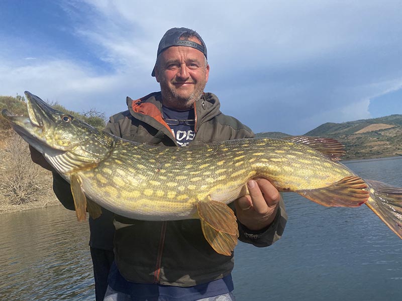 Pecheur avec un brochet sur un lac portugais