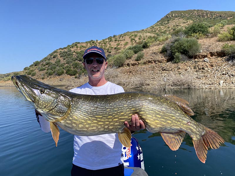 Pecheur avec un brochet sur un lac portugais