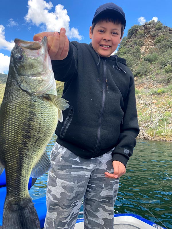Enfant avec un bass à bout de bras sur lac portugais