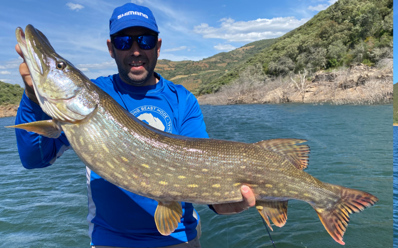 Un pêcheur sur un bateau avec un brochet à bout de bras