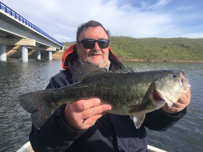 Pecheur Sur Lac Avec Un Poisson De Type Bass